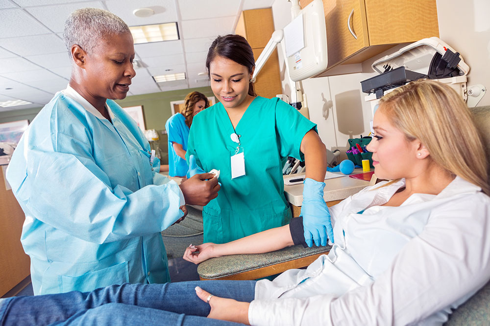 Student nurse and teaching nurse with patient