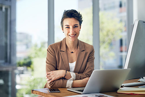 Professional woman seated at a desk with laptop