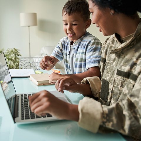 Military woman with child sitting at computer