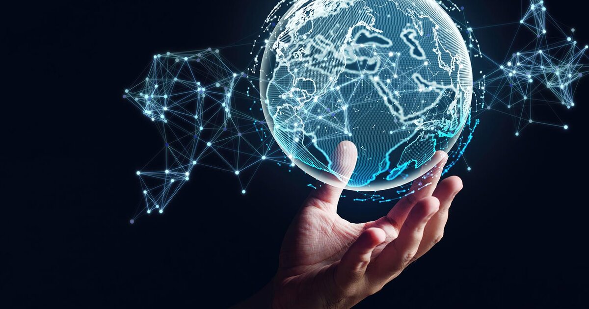 A human hand appears to hold up a hologram of the earth's globe.