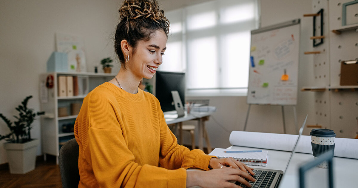 Woman sits at her computer searching for online degrees on ODUGlobal's website. Applying early can help ease your journey to online learning.