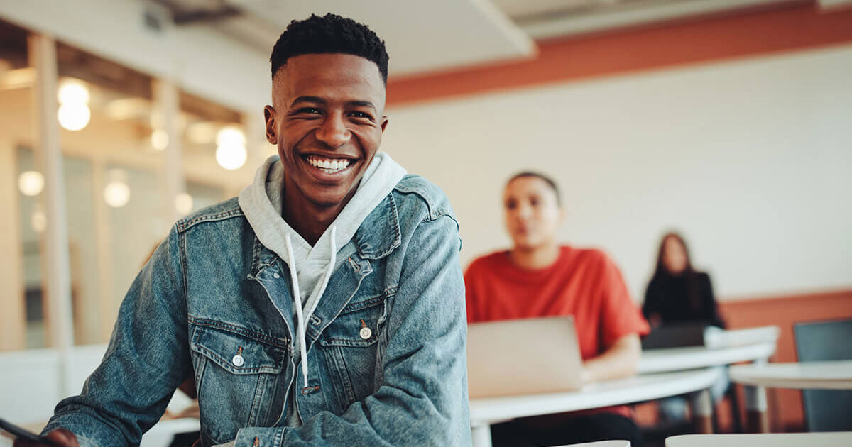 Smiling student seated at desk in classroom