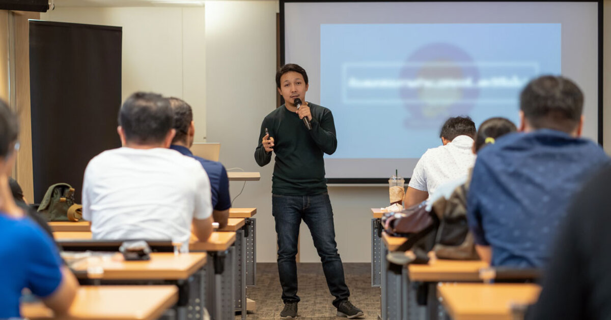 A graduate student speaks about his research to a class of peers