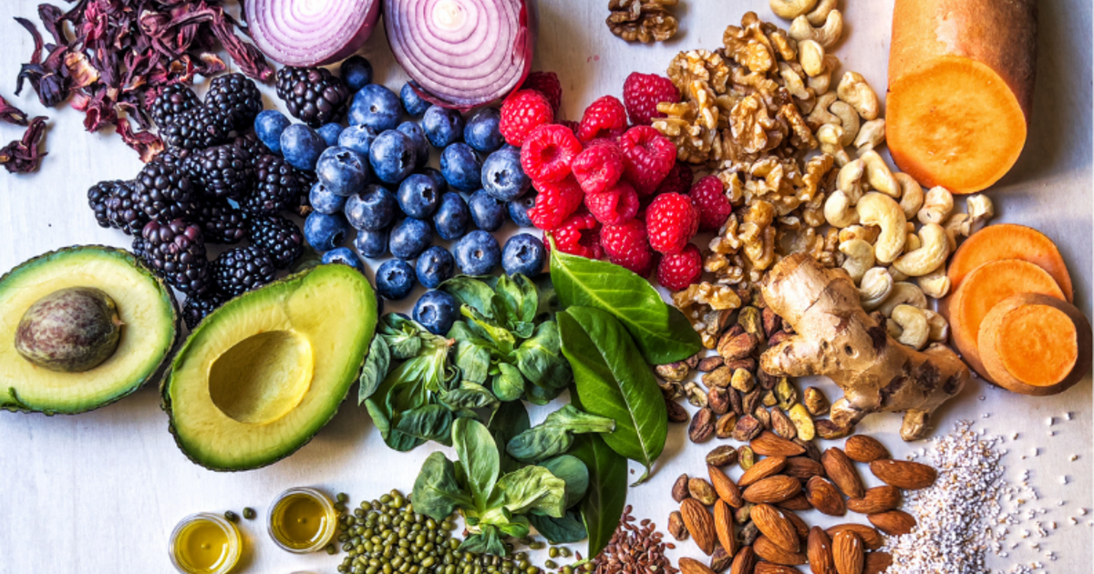 A table top of assorted fruits, vegetables and nuts.