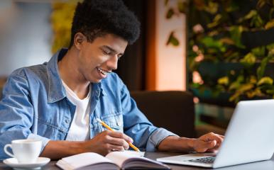 young man taking classes on a laptop