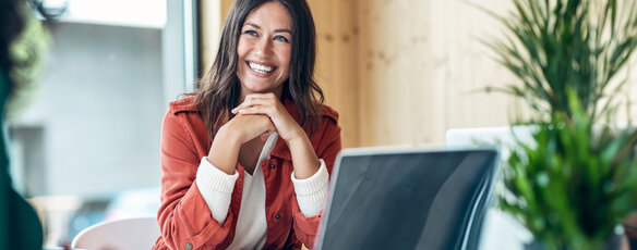 Smiling paralegal sits at a conference table in between working on briefs.