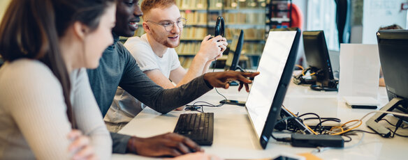 Group of students observing a computer together