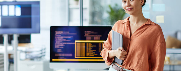 Programmer smiling in front of her computer