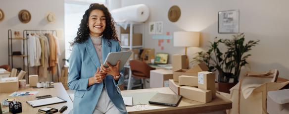 Smiling woman in professional attire smiles in a casual office setting