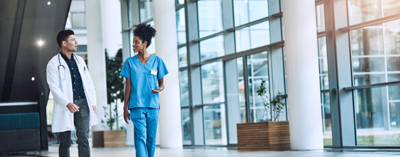 Doctor and nurse collaborating in the hallway