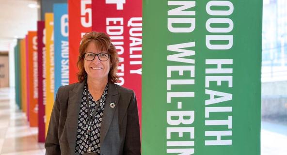 Janice Hawkins stands in front of colorful banners promoting good health at a special event.