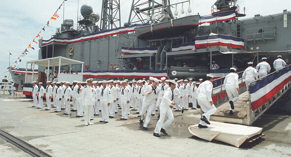 Sailors board the USS Elrod during its commissioning ceremony.