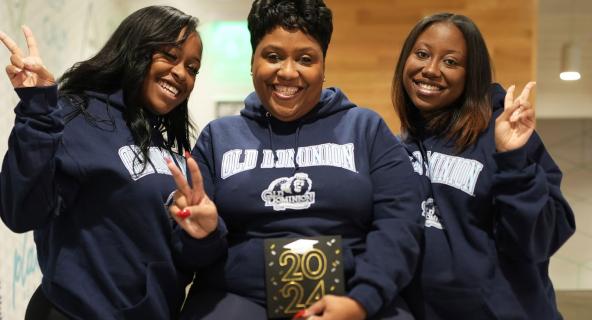 ODU alumnae Jordyn Harrell, left, and Jasmyn Harrell flank their mother Celeste Harrell, who is scheduled to graduate from ODU in May 2023.