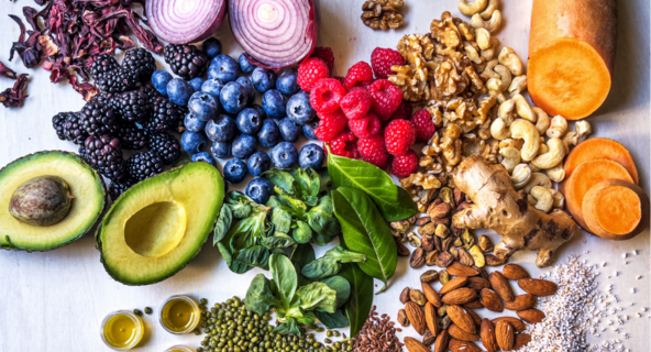 A table top of assorted fruits, vegetables and nuts.