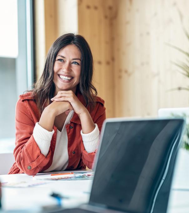 Smiling paralegal sits at a conference table in between working on briefs.
