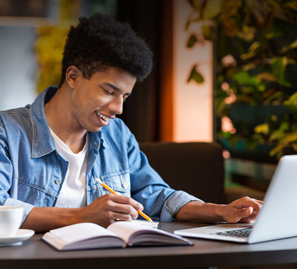young man taking classes on a laptop