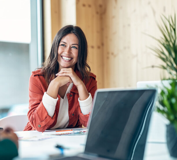 Smiling paralegal sits at a conference table in between working on briefs.