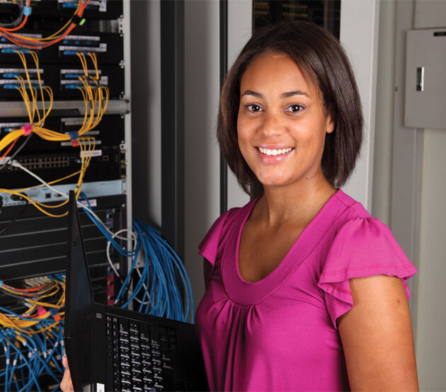 woman standing in front of computer network wiring panel