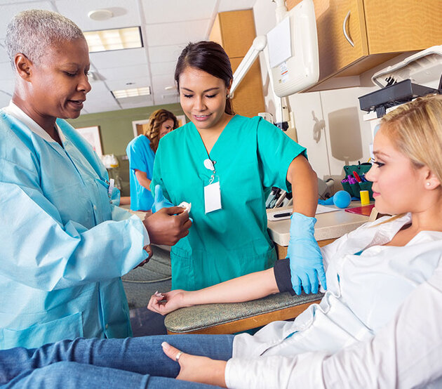 Student nurse and teaching nurse with patient