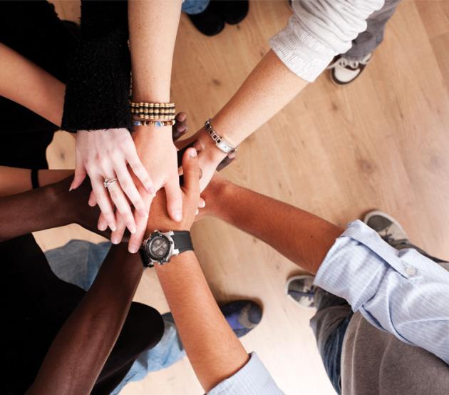 hands reaching out to meet in a huddle