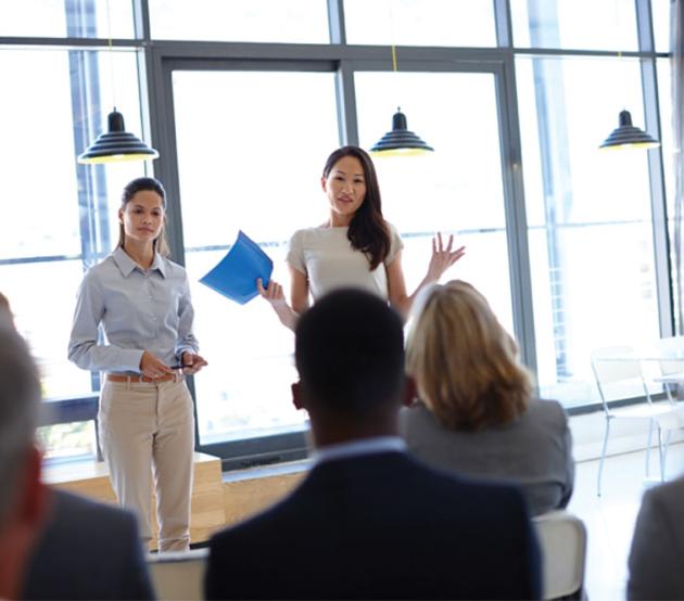 Workplace trainer talks to business professionals after learning occupational studies