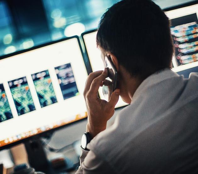 Engineer on the phone looks at a computer screen