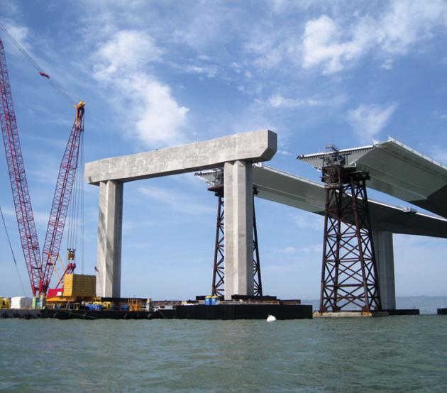 A coastal bridge under construction by civil engineers.