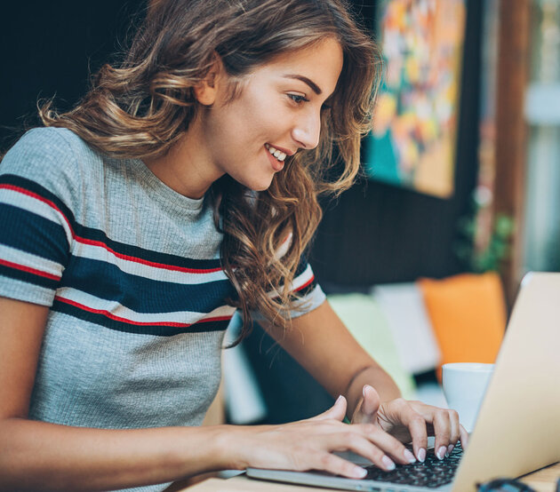 A graduate student connects to online classes while seated at laptop.