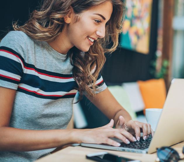 A graduate student connects to online classes while seated at laptop.