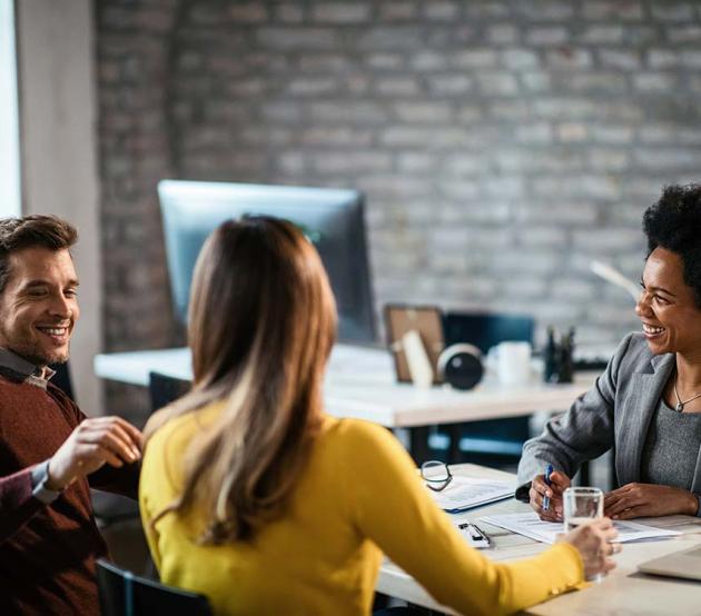 Happy clients with an insurance agent in a casual office