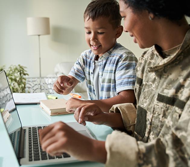 Military woman with child sitting at computer