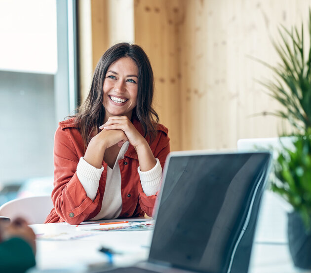 Smiling paralegal sits at a conference table in between working on briefs.