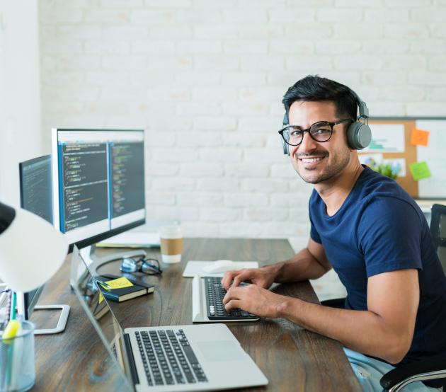 Student sitting at computer working on a software development project