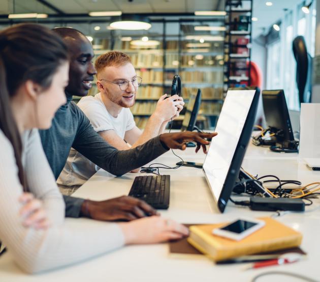 Group of students observing a computer together