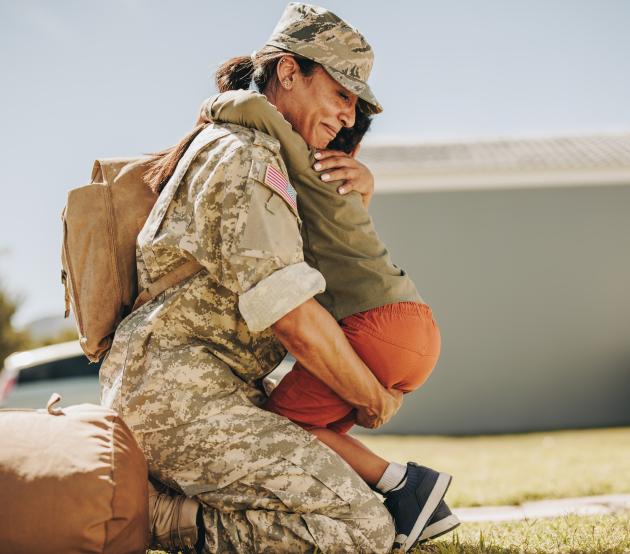 Service member hugging their child after returning home from deployment