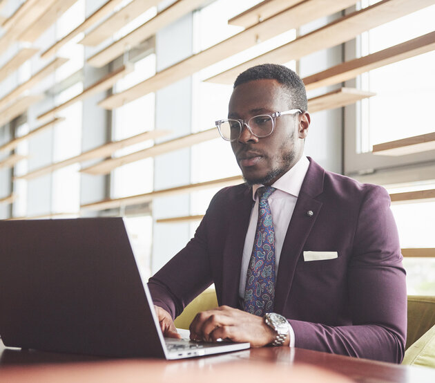 Man wearing a suit seated at a computer