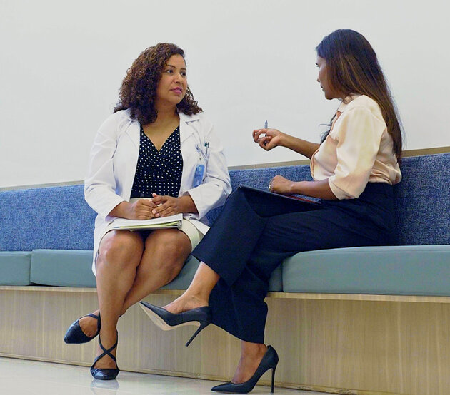 Two people sitting and talking in a modern ODUGlobal office longue.