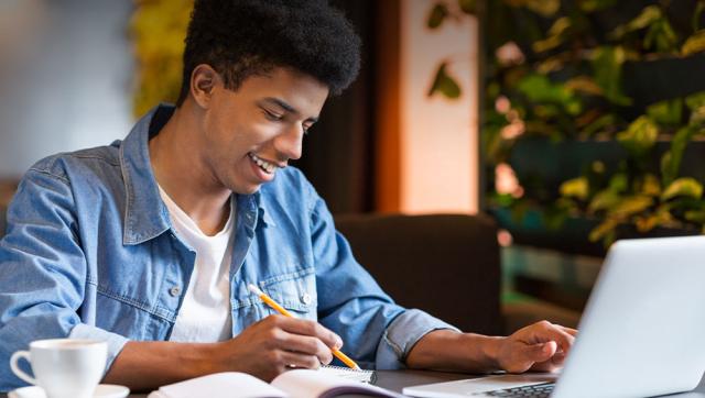 young man taking classes on a laptop