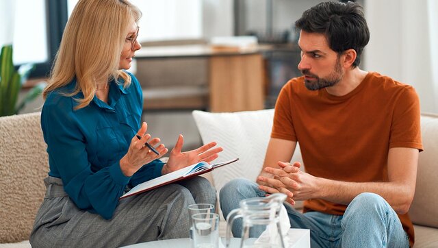 An addiction prevention and treatment specialist chats with a client in a comfortable office to support recovery.