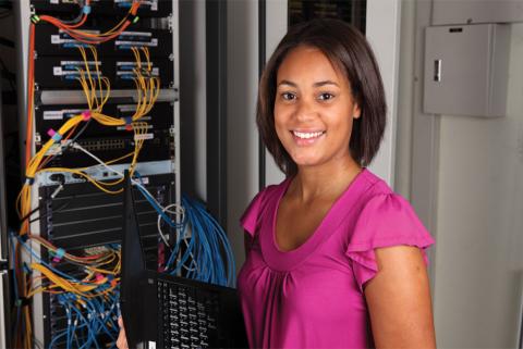 woman standing in front of computer network wiring panel