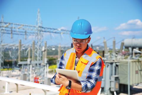 Engineer takes notes while outside a power station
