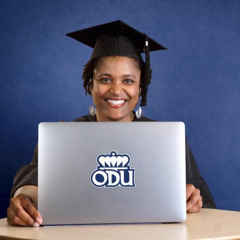 Adult lady smiling at computer with ODU Logo