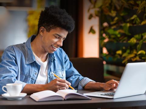 young man taking classes on a laptop
