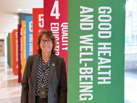 Janice Hawkins stands in front of colorful banners promoting good health at a special event.