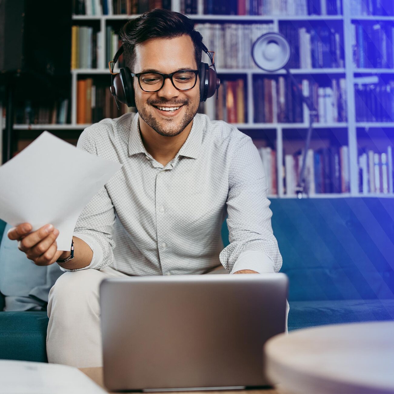 Smiling man with headphones looking at laptop