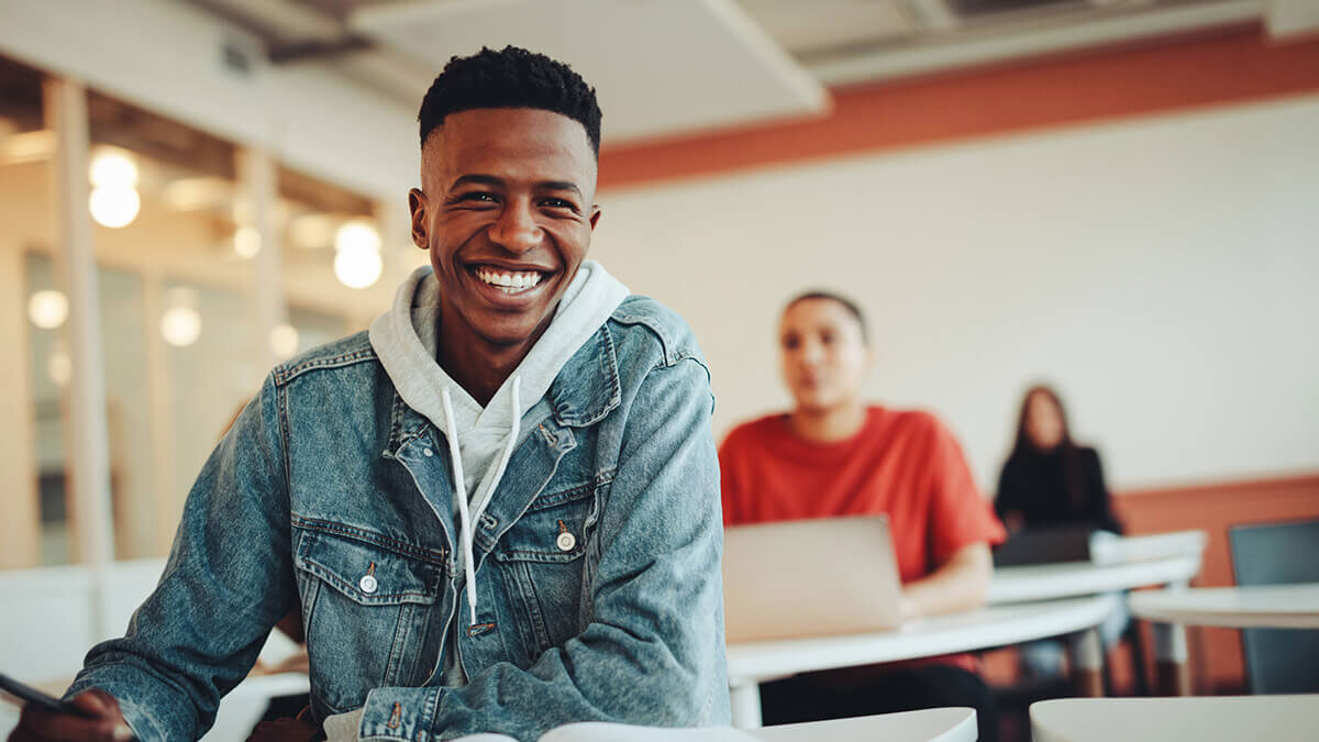Smiling student seated at desk in classroom