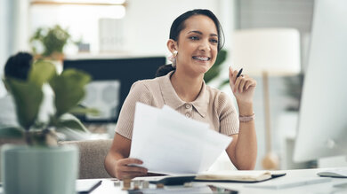 Young smiling accountant, insurance advisor or investment planner working on tax, bills or accounting.