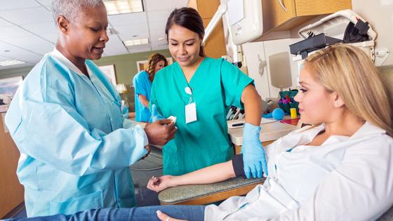 Student nurse and teaching nurse with patient