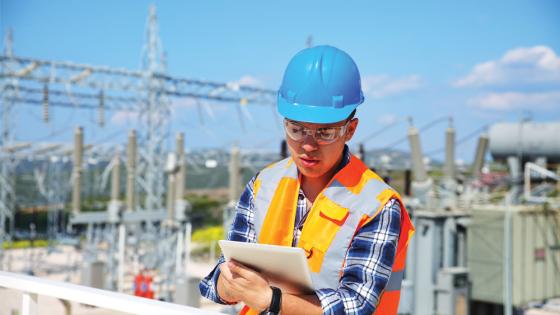 Engineer takes notes while outside a power station