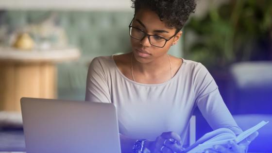 Woman researching online degree programs on her laptop